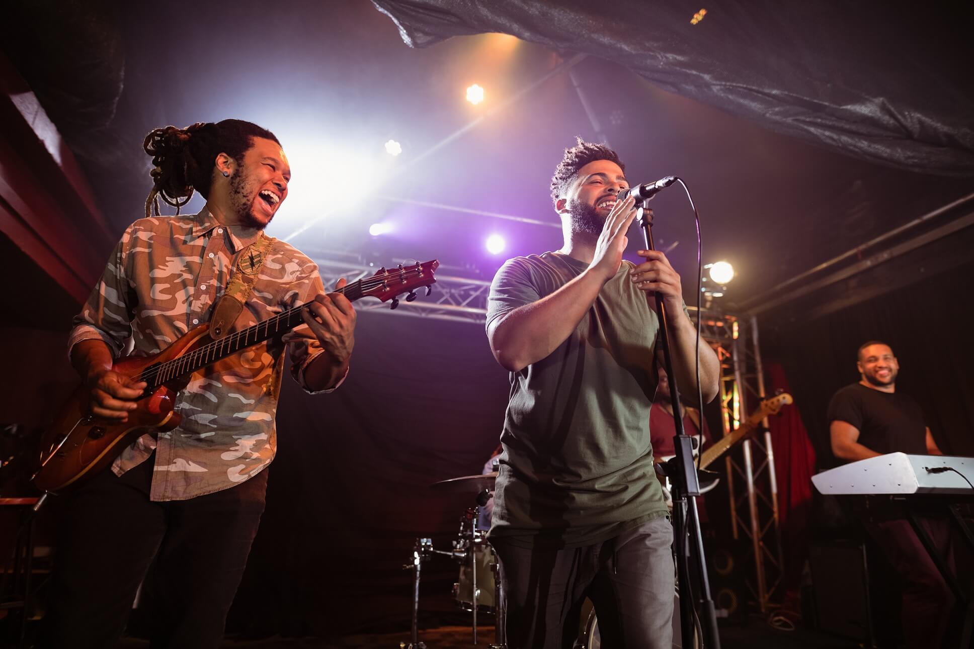 cheerful-guitarist-with-singer-performing-on-stage-DBMSXJX.jpg